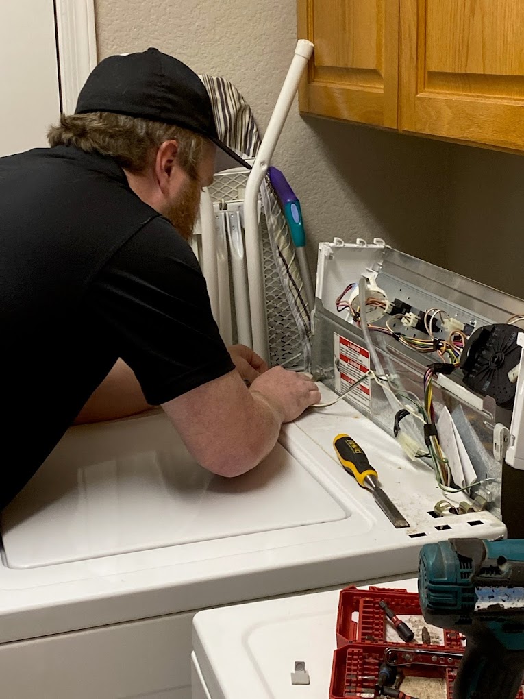 Technician repairing a laundry appliance